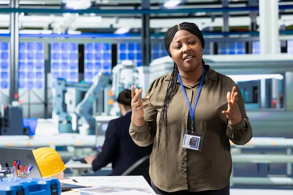 Siyahi kadın müfettiş, daha ucuz çevre dostu enerji elde ederek yeni fotovoltaik üretimini açıklıyor. İş geliştirme için alternatif enerji hakkında tartışan kadın yönetici.