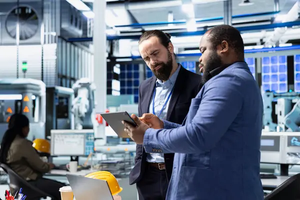 Güneş panelleri için modern üretim hattı üzerinde takım çalışması yapan çok ırklı uzman mühendisler, yenilenebilir enerji altyapısı için teknik içgörü ve işbirliğini birleştirdiler..