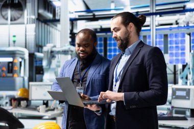 Yüksek teknolojili bir güneş paneli fabrikasındaki veri ve kontrol listelerini inceleyen çeşitli analist ekibi, üretim sürecinin sürdürülebilir enerji ve yenilik standartlarını karşılamasını garanti altına alıyor.