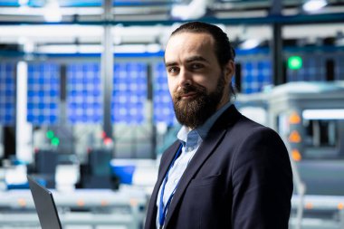 Güneş paneli üretimini izleyen bir giysi fabrikası müfettişi, profesyonel işgal ve yenilenebilir enerji gelişimine idari düzeyde katılımı yansıtıyor. Güneş enerjisi.