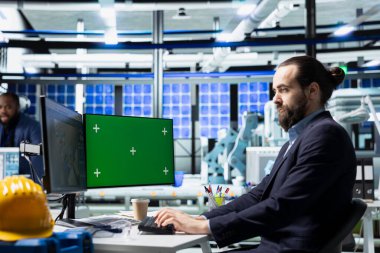 Erkek yenilik danışmanı, bir güneş paneli tesisi, sürdürülebilir enerji gelişimi ve modern üretim süreçleri ile mühendislik güncellemelerini araştırıyor..