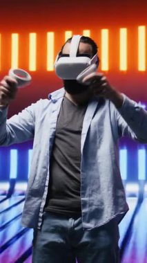 Sanatsal görüş yoluyla sanal gerçeklik gözlüklerini kullanarak, neon ışıklı bir gece sahnesinde yüksek teknolojili VR cihazına sahip dikey Video Young kişisi. Estetiğin parıldayan yansımaları