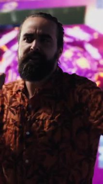 Parlayan neon bir atmosferde, genç kaygısız bir adam eğlenceli dans hareketleri ve yüksek enerjiyle sahneye çıkıyor. Havalı DJ müzik eşliğinde dans ediyor, görsel sanat, teknoloji ve ses sergiliyor. Kamera A.