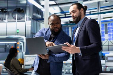 Güneş enerjisi üretimini ele almak için fabrikada toplanan iş arkadaşları fotovoltaik üretim sürecinde takım çalışması gösteriyor. Fabrikada yeşil yenilenebilir enerji sistemi yönetimi.
