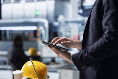 Bir güneş paneli fabrikasının işletme müdürü verimlilik ölçümlerini ve sistem çıktılarını izliyor, gerçek zamanlı kalite denetimi ve stratejik iş geliştirme ile liderliği birleştiriyor.