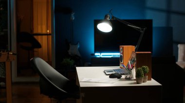 Ahşap mobilyalı, rahat dekorasyonlu, şehir merkezli şık bir dairede modern bir ofis. Ev bitkileri, akıllı bir televizyon ve rahat bir yaşam tarzı için masası olan yaratıcı bir çalışma alanı..