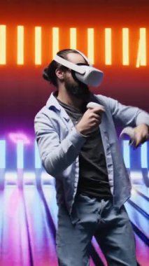 Dikey Video Tarzı genç bir adam sanal gerçeklik kulaklığı kullanarak sanatsal titreşimleri yansıtıyor, eğlencenin esinlendiği siber bir atmosferde renkli neon ışıklarla çevrili. Gece hayatı minimalizmi