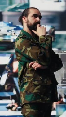 Dikey video erkek ordu subayı, dijital teknolojisi olan bir komuta merkezinden modern savaş stratejisi için uydu istihbaratını takip ediyor. Etkin işlemlerde iletişimi güvene al