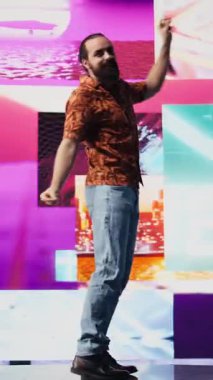 Parlayan neon bir atmosferde, genç kaygısız bir adam eğlenceli dans hareketleri ve yüksek enerjiyle sahneye çıkıyor. Havalı DJ müzik eşliğinde dans ediyor, görsel sanat, teknoloji ve ses sergiliyor. Kamera B.