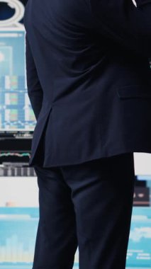 Vertical Video Expert iş adamı akıllı bir telefonla finans ve analizi tartışıyor, bir şirket stratejisi kuruyor. Veri tablolarıyla çevrelenmiş, dijital yenilik ve şirket büyümesi planlanıyor