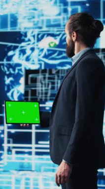 Dikey Video İşletme Yöneticisi, makine öğrenme ve bulut hesaplama sistemleri ile çalışarak, yapay zeka sinirsel ağların yanında model ekran kullanır. Yapay zeka uygulayan genç bir adam. Kamera B.