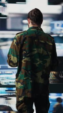 Dikey video silahlı kuvvetleri subayı İHA ve uydu görüntülerini izleyip istihbarat topluyor, savaş planlaması için bilgi topluyor. Görev kontrolü ve siber operasyonlar yoluyla küresel operasyonları güvence altına almak