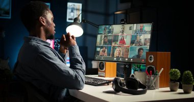 Afrika kökenli Amerikalı bir adam ve yardımcıları çatı katında sanal bir toplantıya katılıyor, bir video konferansı aracılığıyla tartışıyor ve iletişim kuruyorlar, evde uzaktan kumanda yapıyorlar. Kamera A.