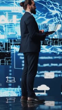 Dikey Video Erkek İş Adamı Yapay Zeka Stratejisi ve Otomasyon Aletleri üzerine çalışıyor. Veri görselleştirmesi, sinirsel ağlar ve bulut hesaplamalarıyla çevrili olarak, akıllı teknolojiyi keşfeder.