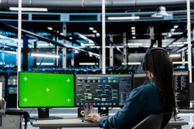 Veri merkezindeki programcı, ekipman performans yükseltme altyapısını kontrol etmek için izole ekran bilgisayarı kullanıyor. Krom anahtar PC kullanarak sunucu odasında süper bilgisayarlarda bakım yapan bilişim uzmanı