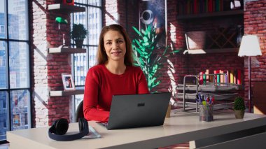 Kendine güvenen bir kadın evdeki serbest bir platformda görevlerini çözüyor, e-postaları cevaplıyor ve birden fazla iş yapıyor. Olgun işçi bağlı kalır ve uzaktan çalışmanın esnekliğinin tadını çıkarır. Kamera B.