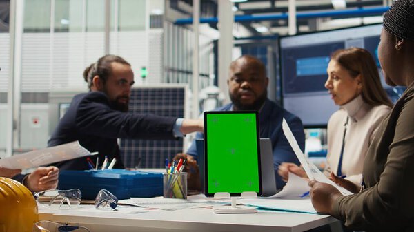 Специалисты фотовольтаического завода разрабатывают прототипы солнечных батарей на макете устройства. Заводские инженеры, использующие изолированные планшеты экрана для уточнения конструкций для увеличения выработки энергии с помощью данных, камера А