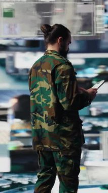 Dijital teknoloji ve uydu verileriyle sanal bir savaş bölgesinde çalışan dikey video ordu subayı, tehdit algılama araçlarını ulusal güvenlik için kullanıyor. Kontrolü sağlamak için modern askeri strateji