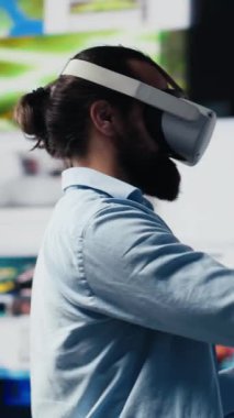 Dikey Video Genç rahat adam sosyal medya platformları için yapay zeka bağlantısı gösteren 3 boyutlu kullanıcı arayüzü tasarımı için VR gözlük kullanıyor. Dijital dünyada eğlence üzerine çalışan erkek sosyal ağ kullanıcısı