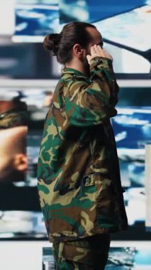 Dikey Video Ordusu subayı, savaş planlama taktikleri ve savaş alanı detayları için önemli bilgiler toplayarak komuta merkezinde saygıdeğer askeri selamlamayı gerçekleştirir. Yüksek teknoloji ordu ortamı