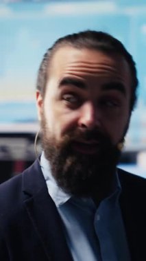 Dikey Video Profesyoneli iş adamı, elleri serbest mikrofon kullanarak sahnede ilham verici bir iş sahası sunuyor. Vizyoner CEO ve motivasyon konuşmacısı, katılımcılara grafikler ve verilerle hitap ediyor