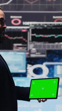 Dikey Video Erkek Yöneticisi dijital çalışma alanındaki yeni büyüme stratejisini anlamak ve analiz etmek için yeşil ekranlı telefonu kullanır. Modern iş zekasını ve verimliliğini temsil ediyor.