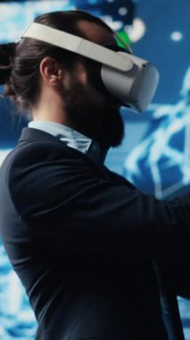 Dikey Video Modern iş adamı, derin öğrenme kavramı için sibernetik ve robotik kullanarak sinirsel ağ sisteminin yanında sanal gerçeklik aygıtı kullanır. Geliştirmek için yapay zeka otomasyon araçları. Kamera.