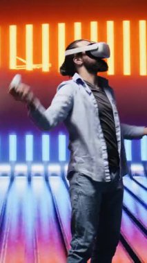 Dikey Video Sanatçısı genç adam, neon ışıklar ve siber punk parıltısı altında sokak stilini modern moda ve teknolojiyle harmanlayarak estetik görsellerle dolu serin bir ortama daldı.