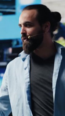 Dikey Video Erkek havalı bilişim uzmanı, elleri serbest mikrofonlu canlı bir kongreye ev sahipliği yaparak, sosyal medya erişimi ve dijital etkileşimi tartışmak üzere sahneden izleyiciler topluyor. İletişim