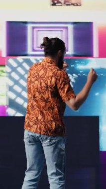 Elektronik ritimler ve sanatsal görsellerle kulüpte dans eden Dikey Video DJ etkileyicisi harika hareketler sergiliyor. Siber punk müzik kültürü ve yaratıcılığı kentsel dijital yaşam tarzını yakalar