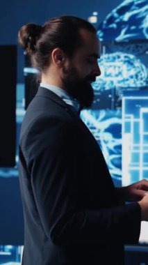 Yüksek teknolojili yenilik ve algoritmik düşünce öğrenmek için dijital yapay zeka sinir ağlarıyla çalışan dikey video işadamı. Mühendis, gelecekteki gelişmeler için veri bilimini kullanıyor