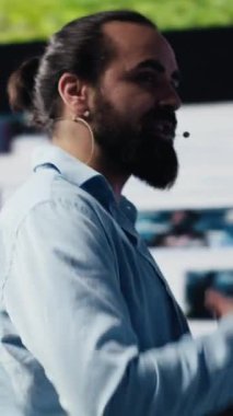 Eller serbest mikrofonlu dikey video, erkek trend belirleyicisi yenilikler için içgörü sunan canlı bir sunum sunuyor. Konuşmacı izleyicilerle çevrimiçi eğlence hakkında konuşuyor. Kamera A.