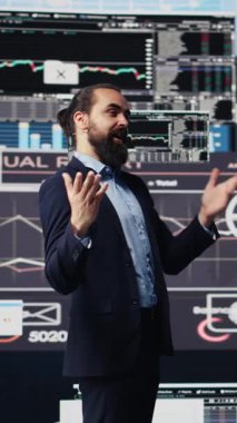 Dikey Video Profesyoneli iş adamı, elleri serbest mikrofon kullanarak sahnede ilham verici bir iş sahası sunuyor. Vizyoner CEO ve motivasyon konuşmacısı, katılımcılara grafikler ve verilerle hitap ediyor