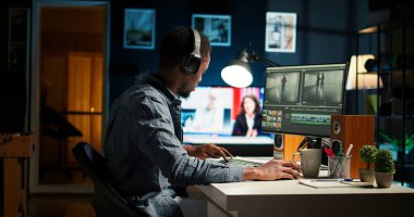 Ev ofis ortamında, dijital medya içeriğinde yaratıcı bir yazılımda video montajı üzerinde çalışan odaklanmış erkek editör. Film yapımcısı, post-prodüksiyondaki görüntüleri düzenlemek için çift monitör kullanıyor. Kamera A.