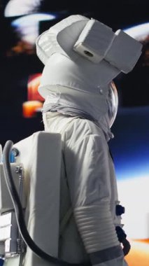 Uzay giysisi içindeki dikey video astronotu Dünya 'nın yörüngesinde süzülerek insanlığın evrene yolculuğunu sembolize eder. Sonsuz keşif, teknoloji ve bilinmeyen evreni keşfetme arayışı.