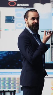 Dikey Video Yöneticisi, büyük veri analizi ve ekonomik tahminleri koordine etmek için telefon görüşmesini kullanıyor. Gösterge panelinde bilgi grafikleri ve şirket performansına rehberlik etmek için modern ölçümler paylaşılıyor. Kamera B