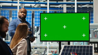 Ofisteki yöneticiler güneş teknolojisi raporlarını yeşil ekran monitöründen inceliyor. Yeşil enerji üretiminde yatırım fırsatlarını tartışmak için model ekran kullanan hissedarlar, kamera B