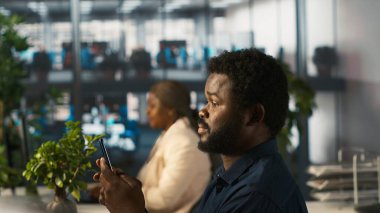 Ofisteki çalışan, akıllı telefon kullanarak dokümanları kontrol etmekten, arkadaşlarına mesaj göndermeye ara veriyor, dinleniyor. Ofisteki muhasebeci cep telefonundaki ve kamera A 'daki mesajlara cevap vermek için görevleri durduruyor.