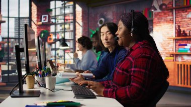 Tecrübeli çağrı merkezi ekip lideri çalışana yardım ediyor ve ofiste kahve içiyor. Asyalı hesap yöneticisi iş arkadaşıyla takım çalışması yapıyor, iş yerinde içeceklerin keyfini çıkarıyor, kamera B