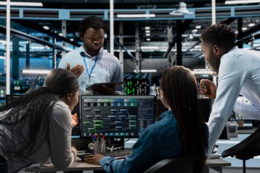 Veri merkezi sistem yöneticileri PC kullanarak birbirine bağlı düğümlerden oluşan yapay zeka sinirsel ağlarını görselleştiriyorlar. Sunucu çiftliği çalışanları beyin fırtınası yapıyor, yapay zeka sistemlerini denetliyor.