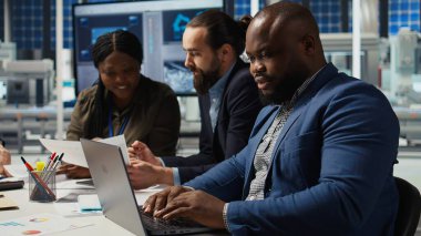 Fabrika ofisindeki mühendisler artan enerji üretimi için dizüstü bilgisayar kullanarak performans verileri topluyorlar. Fotovoltaik uzmanları yenilikçi güneş pili prototipleri tasarlıyorlar, kamera A