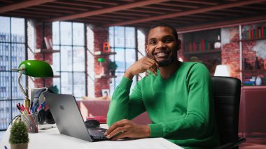 Afrika kökenli Amerikalı uzaktan kumandalı işçi, bilgisayardaki günlük serbest çalışma işlerini hallediyor, modern dairesinin rahatlığı için rahatça çalışıyor. Teknolojiden anlayan siyah adam internet kullanıcısı, birden fazla iş yapıyor. Kamera B.