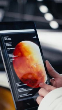 Yüksek teknolojili uzay aracının içindeki dikey video astronotu rutin görev kontrolü sırasında Kırmızı Gezegen özet analizlerini kontrol ediyor. Mars verilerini gösteren monitörün yanında duran aygıtı kullanarak Yörünge İstasyonu Kozmonotu