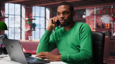 Evde gülümseyen bir adam akıllı telefondan arkadaşlarıyla dostça sohbet ediyor. Afrikalı Amerikalı adam telefon hattında insanları yakalayarak eğleniyor, serbest olarak. Kamera B.