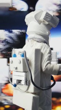 Uzak bir gezegende uzay giysisi ve miğferiyle dikey video meraklısı astronot gökyüzünün altında yıldızlarla dolu örnekler topluyor. Bir uzayda yabancı dünyaları ve kozmik sınırları keşfetmek.