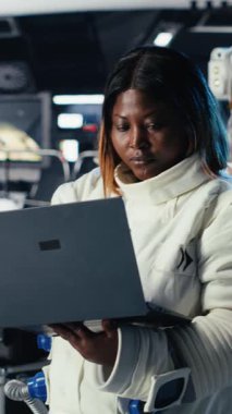 Uzay görevindeki insan genleşmesi sırasında Mars 'ın telemetri verilerini kontrol etmek için tablet kullanan astronotun dikey görüntülerini kapatın. Yıldız gemisindeki kozmonot, insanoğlunun hayatta kalmasını destekleyen kırmızı gezegen yüzeyini analiz ediyor.