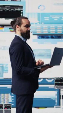 Dikey Video Erkek konuşmacı ve iş koçu canlı seyircilerle dinamik bir sunum yapıyor. Teknoloji güdümlü bir iş etkinliğinde paylaşım stratejisi, büyüme fikirleri ve mali tahminler