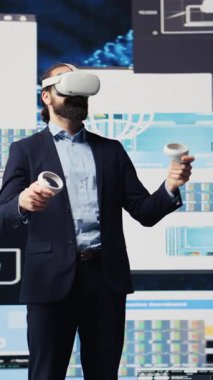 Dikey Video Modern işadamı, performans ölçümleri, teknoloji ve analitik yoluyla stratejik planlama üzerine odaklanmış dijital bir ortamda sanal gerçeklik kulaklığı kullanıyor. Sıkı bir tahminde bulunacağım. Kamera.