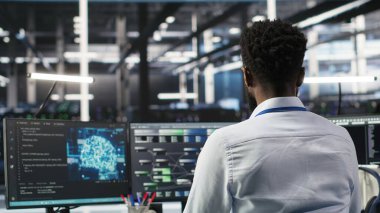 Sistem sağlığını optimize etmek için yapay zeka öğrenme yazılımı kullanan sunucu merkezi programcısı. Veri Merkezi Bilişim Uzmanı Yapay Zeka görselleştirmesi kullanarak ekipman sorunlarını analiz ediyor, Kamera B