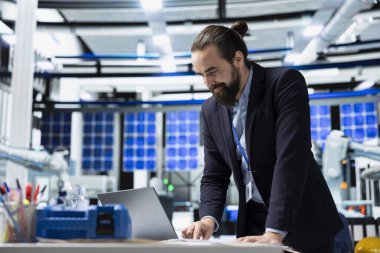 Endüstriyel danışman yüksek teknolojili güneş enerjisi üretim hattını inceleyerek, temiz enerji geliştirme, yenilenebilir sistem tasarımı ve akıllı altyapı planlama kavramlarını gözden geçirir..